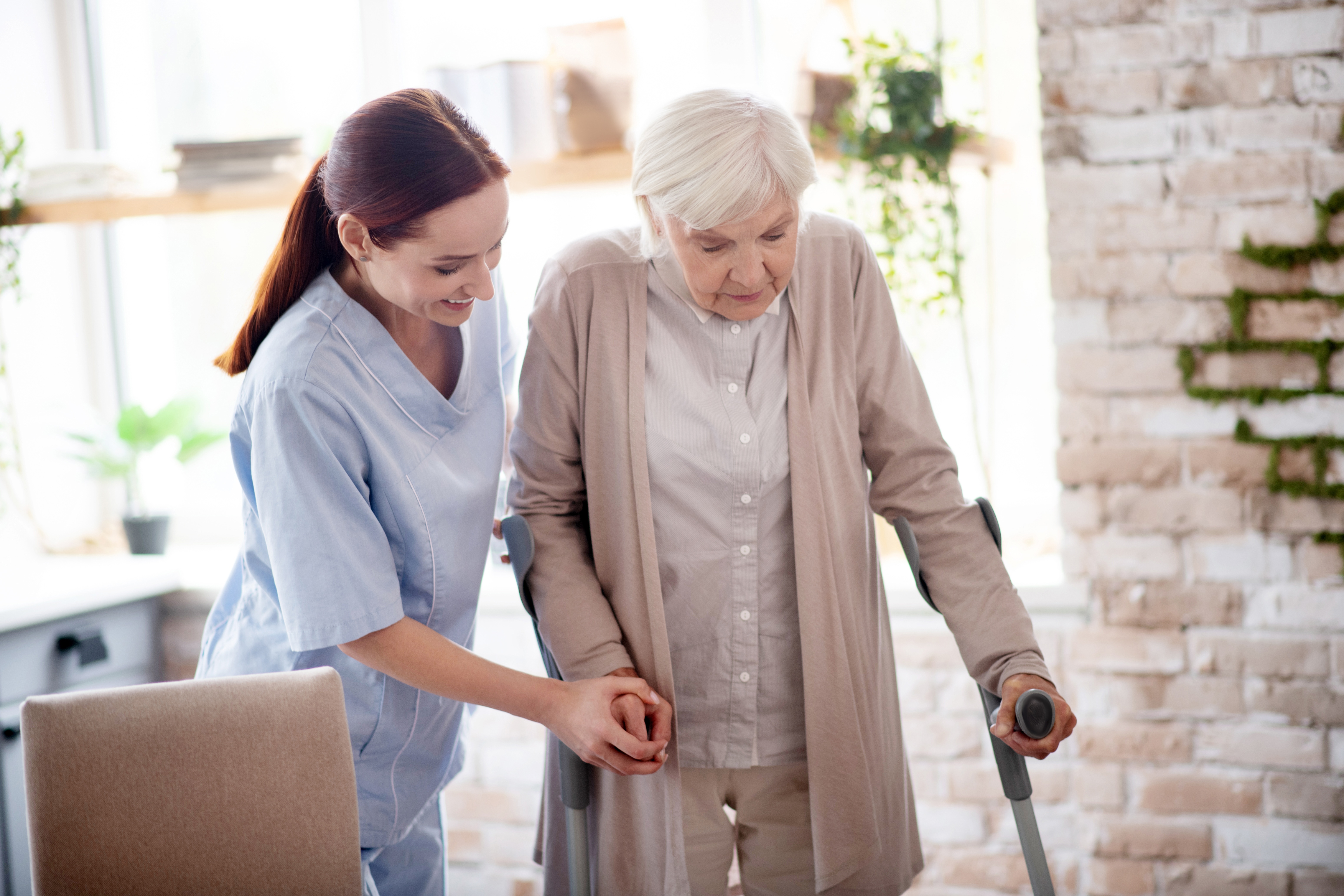 A caregiver at At Serenity Senior Care Homes supports an elderly person