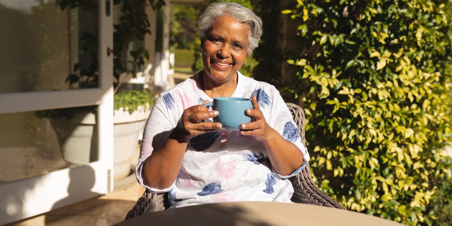 Single-story blue house with a white garage door, a large tree with autumn leaves in front, and a paved driveway leading to the entrance—ideal for comfortable living and easy access to senior care FAQs Snohomish County residents may need.